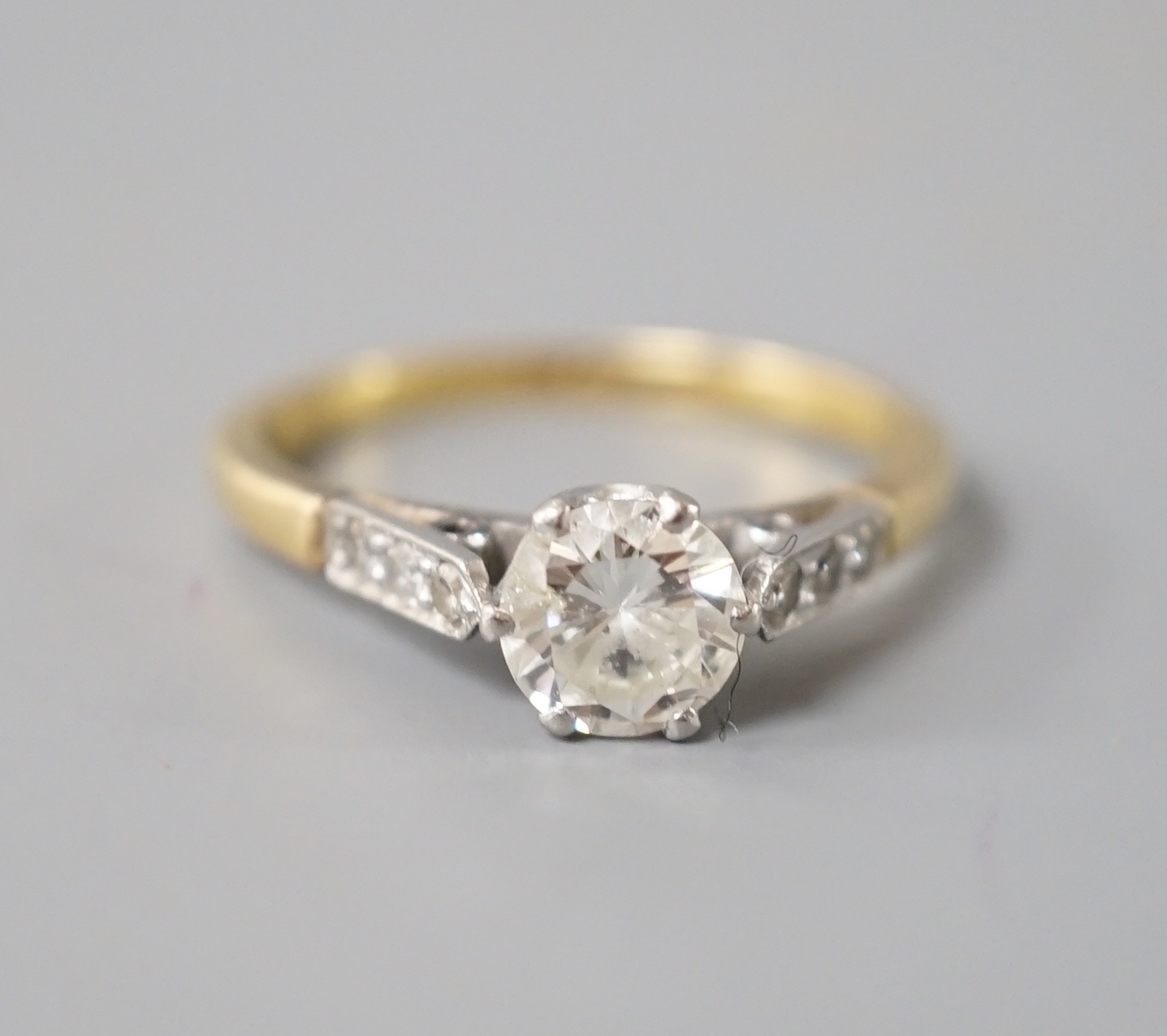 An 18ct & plat, single stone diamond ring, with diamond set shoulders, size N, gross weight 2.7 grams